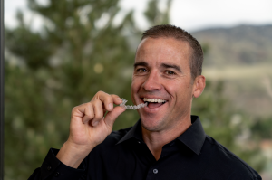 invisalign 101 doctor smiling and holding invisalign