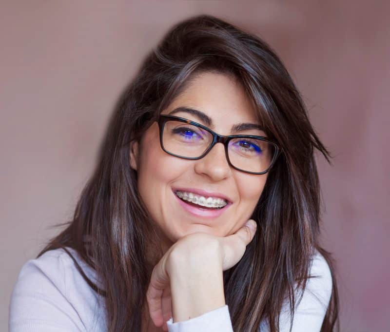 Smiling woman with glasses leaning on hand