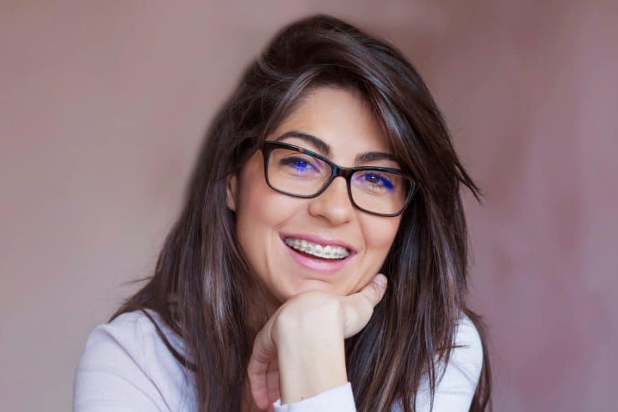 Smiling woman with glasses leaning on hand