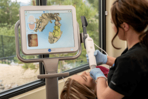 Dentist performing digital dental scan on female patient