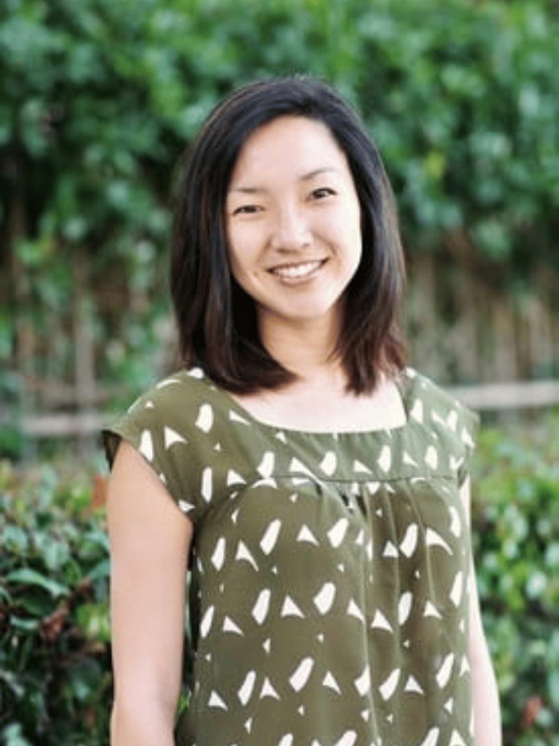 Smiling woman in green patterned blouse outdoors